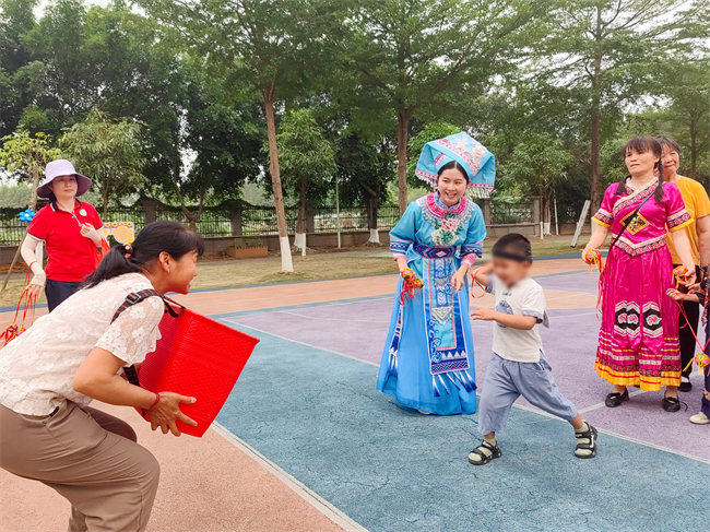 图为家长与幼儿进行抛绣球游戏